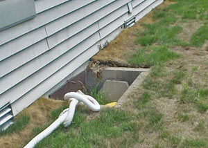 The ugly, old concrete window well of a Benton crawl space
