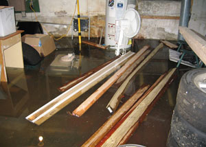 A severely flooding basement in Bryant, with lumber and personal items floating in a foot of water
