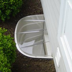 A vinyl basement window and covered window well in Sweet Home