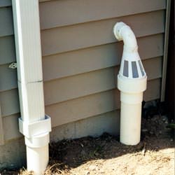 A grated sump pump discharge line fitting in Adona