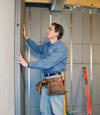 Insulated basement wall panels being placed against a concrete foundation wall in Mabelvale